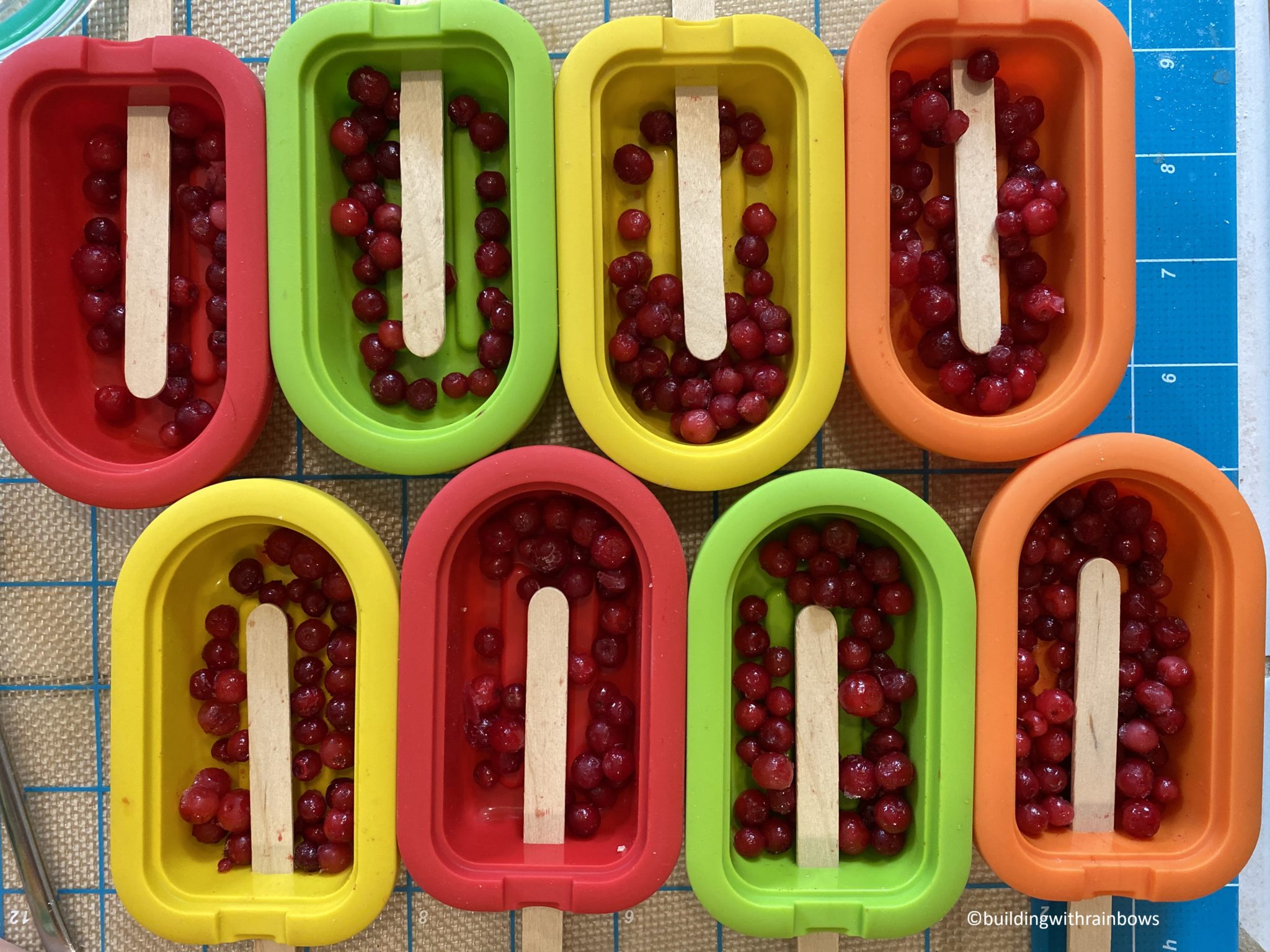 Low mess kid friendly frozen fruit pops building with rainbows